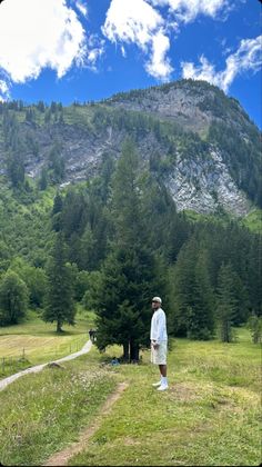 a man standing on top of a lush green hillside