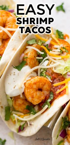 three shrimp tacos with lettuce and cheese on top