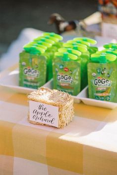 there are many green juices on the table and one has a sign in front of it