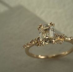 an engagement ring with a fancy diamond in the center and small flowers on the side