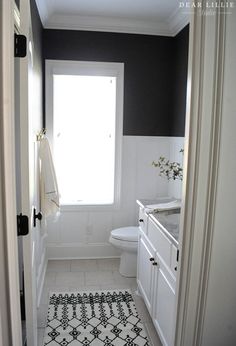 a bathroom with black and white decor on the walls