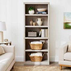 a living room filled with furniture and a white couch next to a wall mounted painting