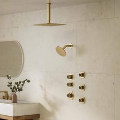 a bathroom with a sink, mirror and gold faucet on the wall above it