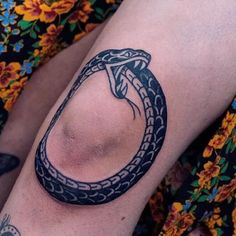 a woman's arm with a tattoo on it and a snake wrapped around the arm