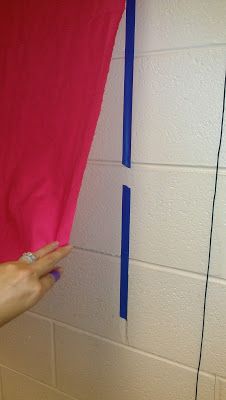 someone is painting the wall with pink and blue tape