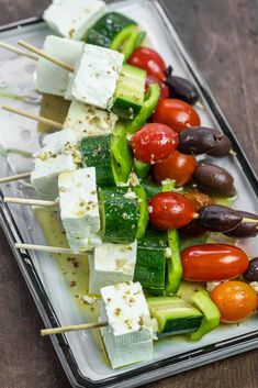 several skewers of vegetables and cheese on a tray