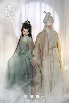 two dolls are dressed in traditional chinese costumes