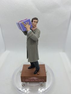 a figurine of a man holding a gift box