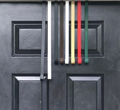 the door is painted black and has five different colored bars attached to it