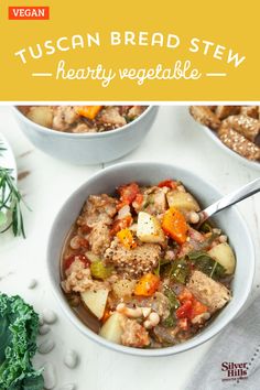 two bowls filled with hearty vegetable stew on top of a white table next to vegetables