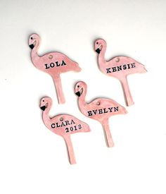 three pink flamingos with names on them sitting next to each other in front of a white background