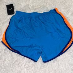 Nike Womens Dri Fit Running Shorts In Blue And Orange Size Small New With Tags And Liner Blue Nike Athletic Shorts For Gym, Casual Gym Shorts With Color Block, Casual Color Block Gym Shorts, Nike Multicolor Sports Bottoms, Casual Stretch Color Block Shorts, Nike Blue Sporty Shorts, Blue Sports Shorts With Pockets, Color Block Gym Shorts, Orange Workout Shorts With Pockets