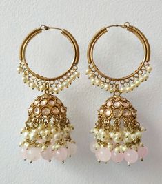 Presenting our Baby Pink Bridal Round Jhumka Earrings, a true embodiment of traditional elegance and grace. These exquisite earrings, adorned with hanging pearls and Polki stones, encapsulate the essence of Indian and Pakistani Chandbali designs, reminiscent of the renowned bridal jewelry style inspired by Sabhyasachi. Materials: Brass, Copper, Pearl, Polki Stones ❋❋ Shipping Methods ❋❋ Standard Delivery - Take up to 8-14 business days (Worldwide). ❋❋ Please be aware that the colors, shades, and texture shown may exhibit minor variations compared to the actual product due to limitations in digital imaging. We kindly ask for your understanding and consideration of these slight discrepancies. ❋❋ Handmade Bollywood Jhumkas For Celebrations, Festive Hoop Earrings With Latkans For Navratri, White Hoop Earrings With Latkans For Celebration, White Hoop Earrings With Latkans For Festive Occasions, White Handmade Chandbali Jhumkas, Festive White Hoop Earrings With Latkans, White Round Tilla Danglers, White Tilla Danglers, Traditional Hoop Earrings With Latkans For Navratri