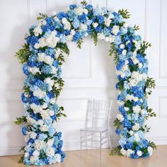 a blue and white floral arch with chairs