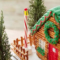 a gingerbread house with a candy cane in the foreground