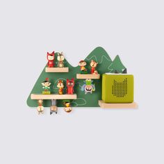 a green shelf with toy animals on it and a radio next to it in front of a mountain