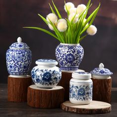 three blue and white vases with flowers in them