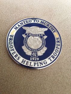 a badge on the back of a couch that says, manto to murrieth police officers helping troops