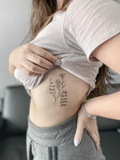 a woman with a flower tattoo on her stomach and the words, love is in bloom