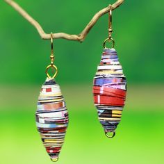 two colorful earrings hanging from a tree branch