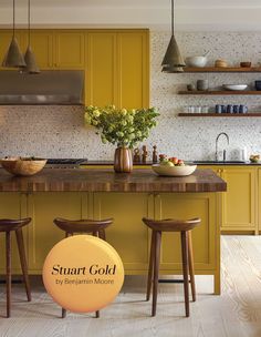 a kitchen with yellow cabinets and stools next to a counter top that says smart gold