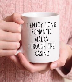 a woman holding a white coffee mug that says i enjoy long romantic walks through the casino