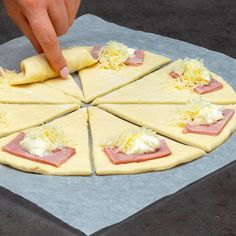 a person making pizzas with cheese and ham on top of them, as well as toppings