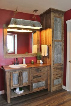 a bathroom with red walls and wooden cabinets