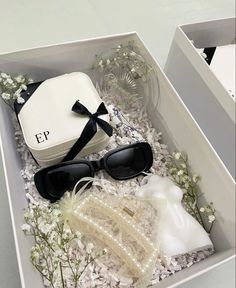 an open box with sunglasses and pearls in it