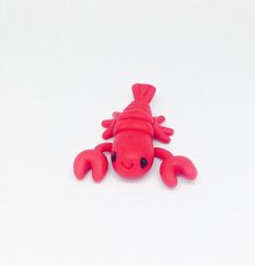 a red toy crab on a white surface