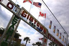 a sign that is on the side of a building with flags flying in the wind