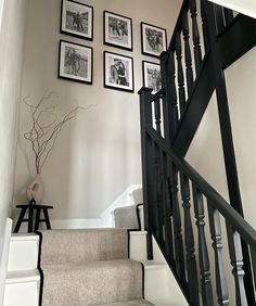 a staircase with pictures on the wall above it