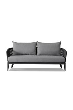 a gray couch with two pillows on it's back and arms, sitting against a white background