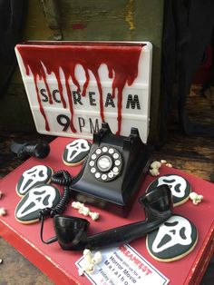 an old fashioned phone is on display in front of a sign with blood dripping down it