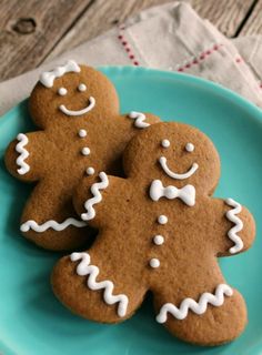 two gingerbread cookies with icing on a blue plate