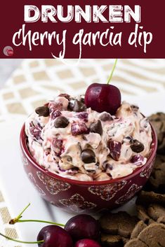 a bowl filled with cherries and chocolate chips next to crackers on a table