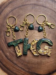 the word keychain is made out of wood and has green marble letters on it