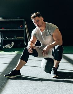 a man squatting down on the ground with his feet crossed