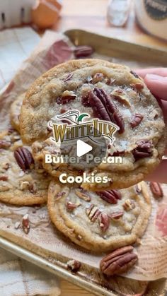 someone is holding up some cookies with pecans on top and the words, white lily but