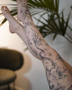 a person with tattoos on their arms and legs is holding a plant in the air