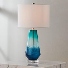 a blue glass lamp on a marble table