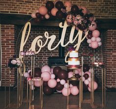 a cake on a table with balloons and a sign that says lorvy above it