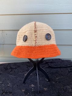 an orange and white crocheted hat sitting on top of a table