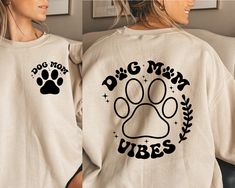 a woman wearing a dog mom sweatshirt with her paw print on the front and back