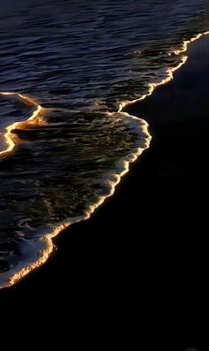 the waves are coming in to the shore at night, and there is no image on it