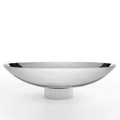 a silver bowl sitting on top of a white table