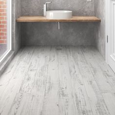 a white sink sitting on top of a wooden counter next to a window in a bathroom