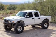 a white truck parked on top of a dirt road