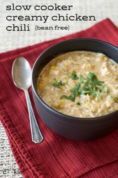 a bowl of slow cooker creamy chicken chili is on a red napkin with a spoon