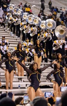 the cheerleaders are all dressed in black and gold